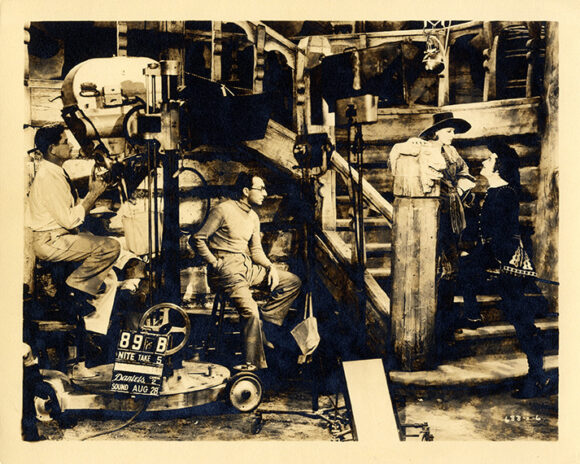 Queen Christina [Los Angeles: MGM, 1933] 8 x 10" double weight sepia-tone photo on matte-finish paper. Shows director Rouben Mamoulian on set with Greta Garbo and John Gilbert on right and cinematographer William Danielson on left.