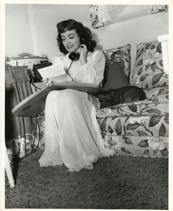 JOAN CRAWFORD READS FAN MAIL IN MGM PORTABLE DRESSING ROOM (1942) BTS photo